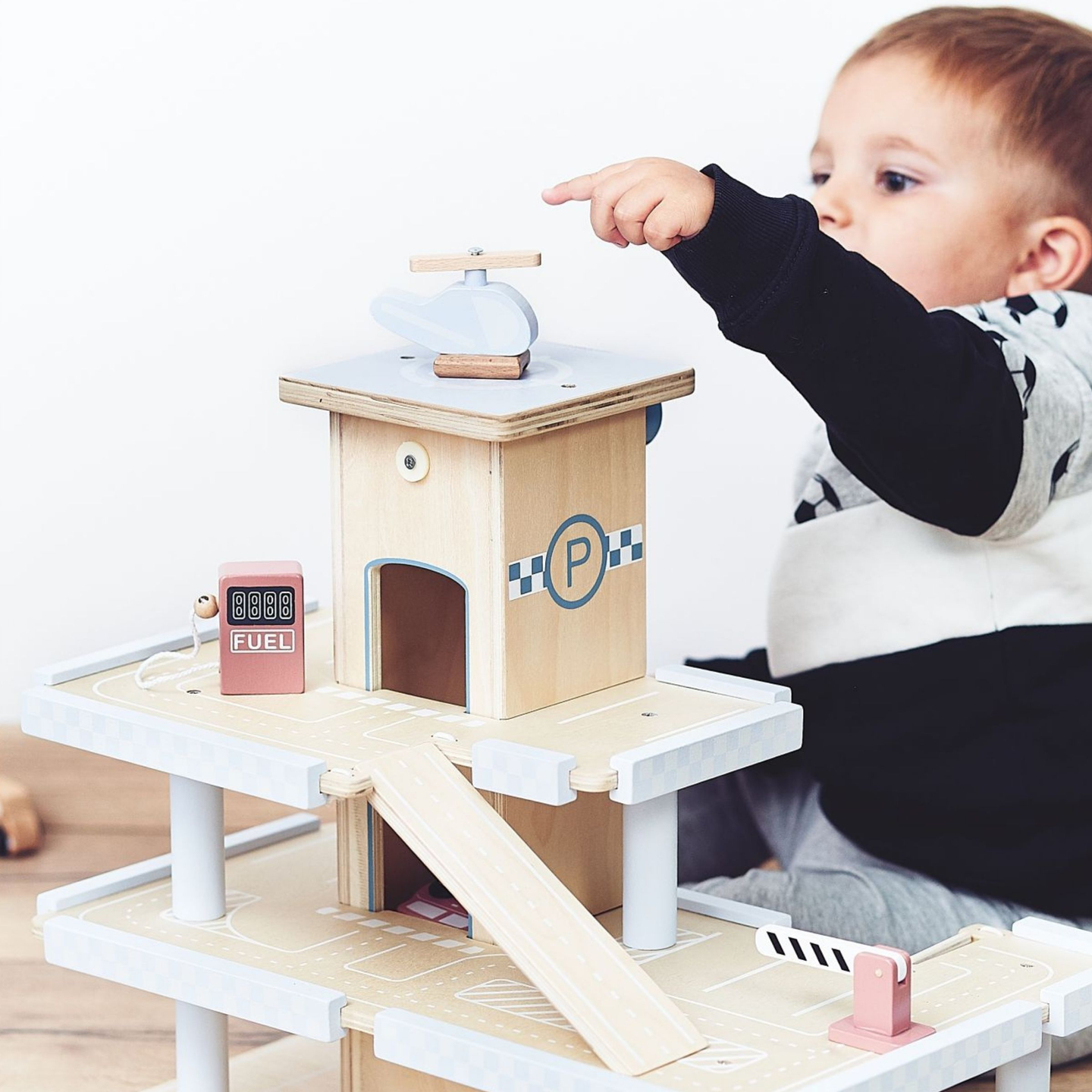 Koka trīsstāvu autostāvvieta ar liftu - garāža ar automašīnām un helikopteru