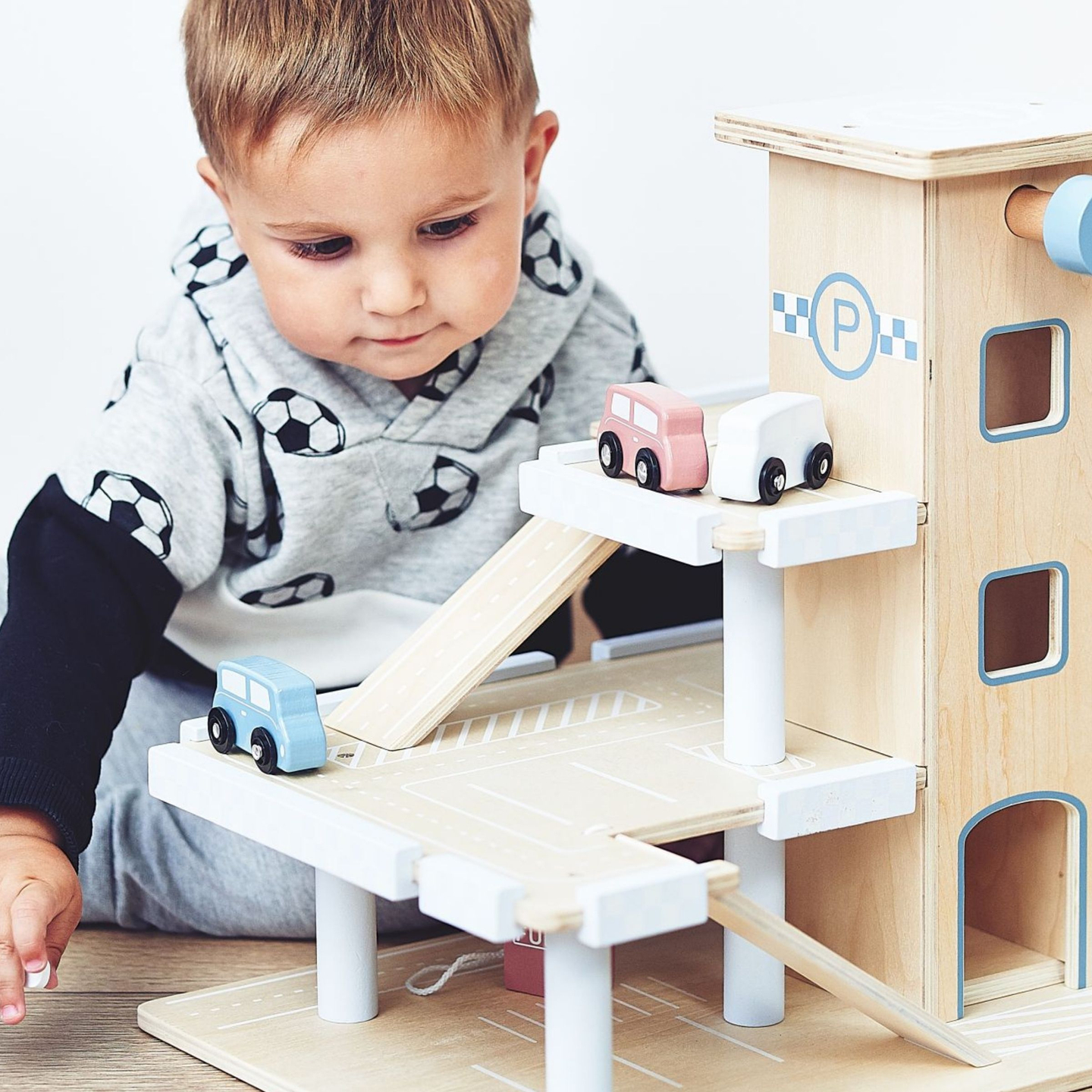 Koka trīsstāvu autostāvvieta ar liftu - garāža ar automašīnām un helikopteru